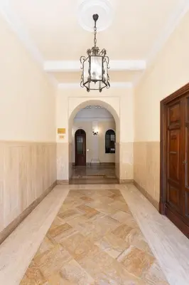 an empty room with a chandelier and a hallway at Colosseo House in Rome