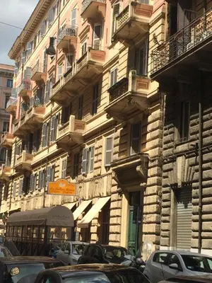 a tall building with cars parked in front of it at Casa Vacanza Colosseo in Rome