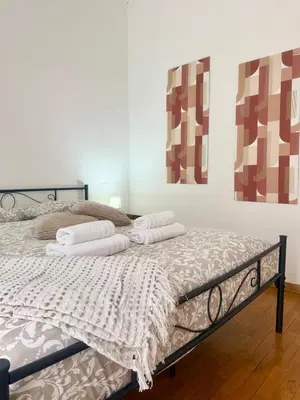 a bed in a room with two paintings on the wall at Volupta's House Janiculum Hill in Rome