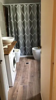 a bathroom with a toilet and a sink and a washing machine at Boncompagni Suite Roma in Rome
