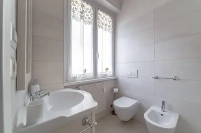 a white bathroom with a sink and a toilet at 35 Gozzadini in Rome