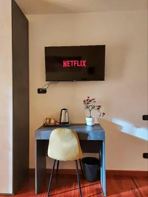 a desk with a chair and a television on a wall at Tre Fiori in Rome