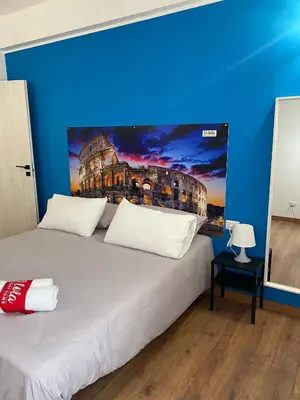 a bedroom with a large bed with a painting on the wall at Lola Holiday Home, Roma Ostiense in Rome