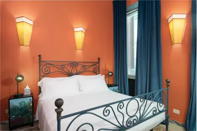a bedroom with orange walls and a bed with white pillows at Appartamento Tor Millina 4 Piazza Navona in Rome