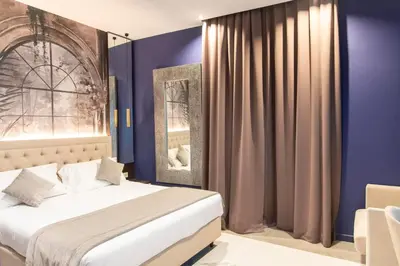 a bedroom with a bed with blue walls and a window at Adelaide Suite Dreams in Rome