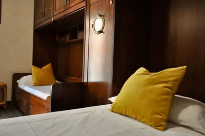 a bedroom with two beds with yellow pillows and a mirror at Le 3 Elle Vaticano San Pietro in Rome
