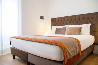 a bedroom with a large bed with a brown headboard at Michelangelo Vatican Guest House in Rome