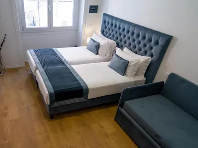 a bedroom with a large bed and a couch at Michelangelo Vatican Guest House in Rome