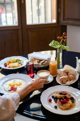 a table with plates of breakfast food on it at Palazzo Talìa - Small Luxury Hotels of the World in Rome