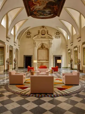 a lobby with couches and tables in a building at Palazzo Talìa - Small Luxury Hotels of the World in Rome