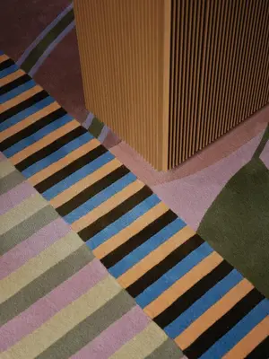 a colorful rug on the floor next to a box at Palazzo Talìa - Small Luxury Hotels of the World in Rome