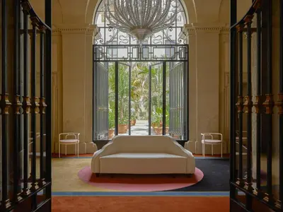 a white couch in a room with a large window at Palazzo Talìa - Small Luxury Hotels of the World in Rome