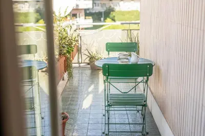 two green chairs and a table on a balcony at BigFamilyRome-Vatican&Aurelio in Rome