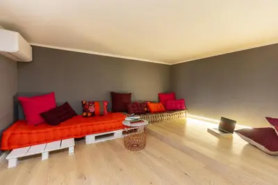 a living room with an orange couch and red pillows at Colosseo View Atmosphere by Rental in Rome in Rome