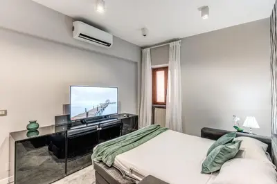 a bedroom with a bed and a flat screen tv at R22 Apartment in Rome