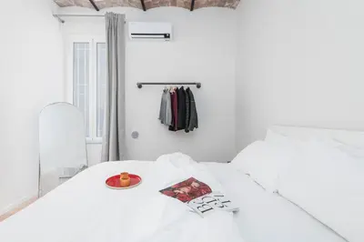 a white bed with a bowl of fruit on it at Monti Zen Boutique Apartment-ZEN25 in Rome
