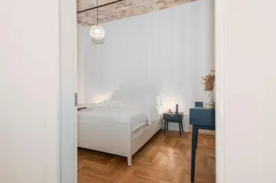 a white bedroom with a bed and a table at Monti Zen Boutique Apartment-ZEN25 in Rome
