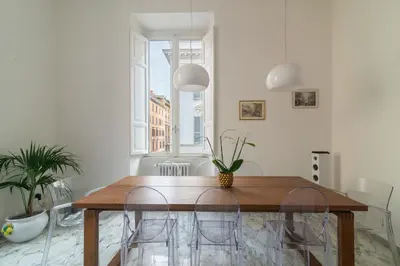 a dining room with a wooden table and chairs at Aureliana luxury apartment in Rome