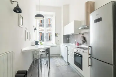 a kitchen with white appliances and a refrigerator at Aureliana luxury apartment in Rome
