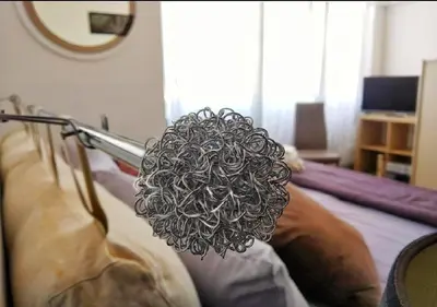 a person holding a metal object on a bed at 