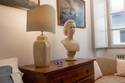 a table with a lamp and a bust on it at Farnese Apartment Navona Historic Center in Rome