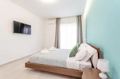 a white bedroom with a bed and a tv at 2-Bedroom Retreat near Metro & Parks in Rome