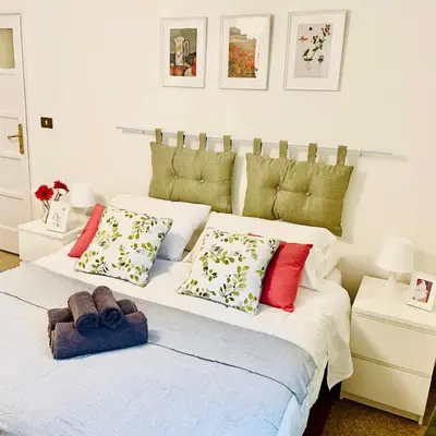 a white table and chairs with red flowers on the wall at Holiday Homes Rome - Monte Verde 61 - near Trastevere in Rome