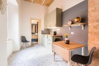 a kitchen with a wooden table and two chairs at FAMM Apartments - Open space in Trastevere in Rome