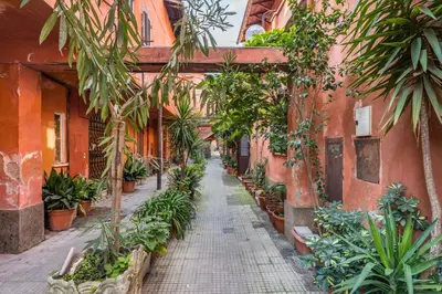 an alley in an old building with potted plants at FAMM Apartments - Open space in Trastevere in Rome