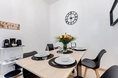 a dining room with a table with chairs and a clock at Classy 2-bdr in Termini district in Rome
