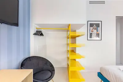 a room with a yellow staircase and a black chair at Mom's home - A few stops from the city centre in Rome