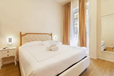 a white bedroom with a large bed and a window at Hotel Domus Rome in Rome