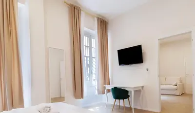 a white room with a desk and a tv on a wall at Hotel Domus Rome in Rome