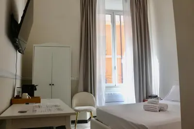 a bedroom with a bed and a desk and a window at Hotel Domus Rome in Rome