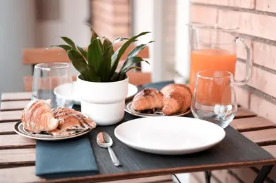 a table with plates of pastries and a glass of orange juice at Suite 52 Trastevere in Rome