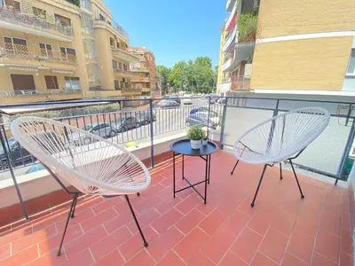 two chairs and a table on a balcony at Golden Essence Apartment - terrace & metro in Rome