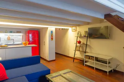 a living room with a blue couch and a red refrigerator at Saint Louis Penthouse, cozy little apartment next to Pantheon in Rome