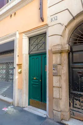 a green door on the side of a building at Saint Louis Penthouse, cozy little apartment next to Pantheon in Rome