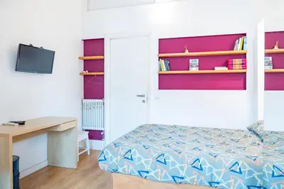 a bedroom with a bed and a desk and shelves at Lion 99 in Rome