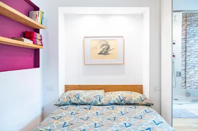 a small bedroom with a bed and a bathroom at Lion 99 in Rome