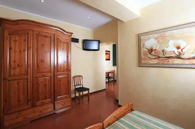 a bedroom with a bed and a large wooden cabinet at Casa Di Santa Francesca Romana a Ponte Rotto in Rome