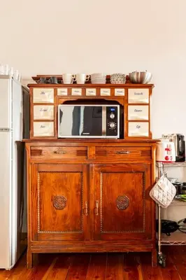 a microwave on top of a wooden cabinet in a kitchen at Delizioso appartamento a Trastevere in Rome