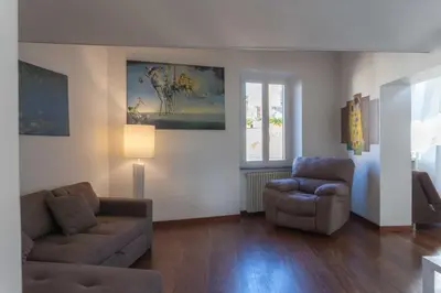 a living room with a couch and a chair at Lusso e panorama senza paragoni, Loft Trastevere in Rome