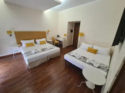 a bedroom with two beds and a table and a desk at Caesar Place in Rome