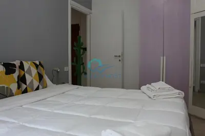 a bedroom with a white bed with towels on it at Cozy Haven near Caracalla Baths Your Home in San Giovanni in Rome
