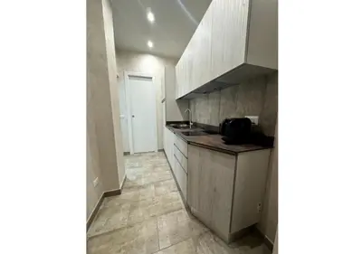 a kitchen with white cabinets and a tile floor at La Palmetta - Vicino Metro A in Rome