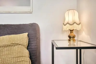 a lamp on a glass table next to a bed at Hella Urbana 152 in Rome