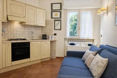 a living room with a blue couch and a kitchen at èROMA - AVENTINO Apartment in Rome