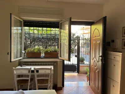 a kitchen with a table and chairs and a window at èROMA - AVENTINO Apartment in Rome
