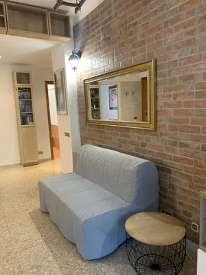 a blue couch in a room with a brick wall at Valerie house Garbatella in Rome